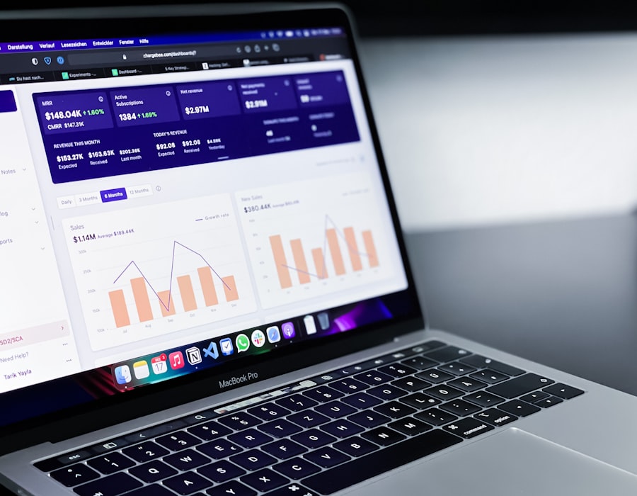 Dashboard d'application financière sur MacBook Pro — KPI mensuels en barres et courbes.