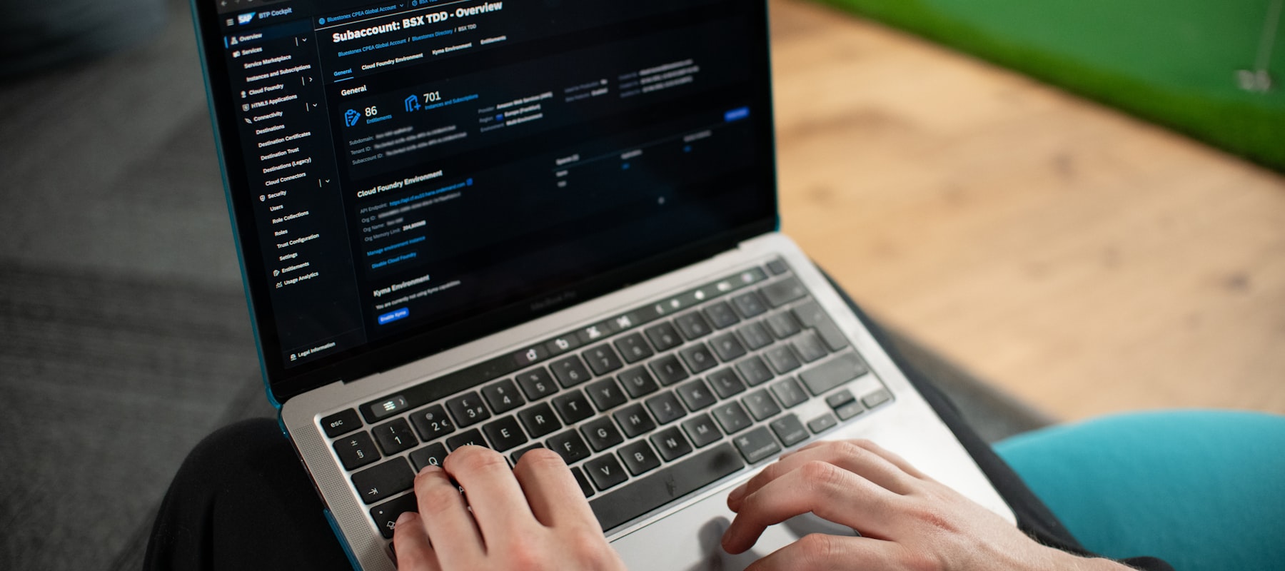 MacBook ouvert sur un éditeur de code en thème sombre — mains qui tapent.